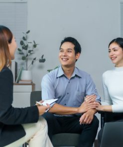 Cặp đôi nắm tay nhau, mỉm cười lắng nghe trong buổi tư vấn tâm lý